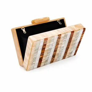 Détail de la pochette de soirée en acrylique à rayures marbrées avec chaîne dorée
