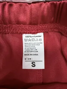 Macro shot of wine red polyester fabric detail and care label on fitness shorts