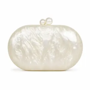 Macro shot of pearl white acrylic clutch bag with decorative twin pearl clasp closure