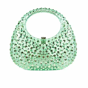 Detail of mint green acrylic crescent clutch bag with sparkling rhinestones for parties