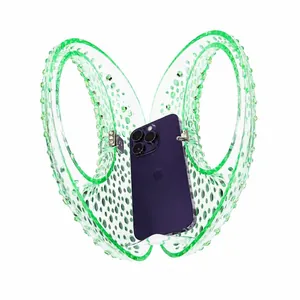 Macro view of neon green transparent acrylic clutch bag with studded texture and metal clasp
