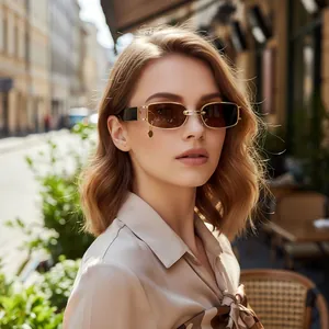 Detail of vintage gold metal rectangle sunglasses with deep brown lenses and a round pendant