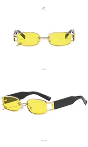 Detail view of gold metal square sunglasses with yellow lenses and hollow decorative frames
