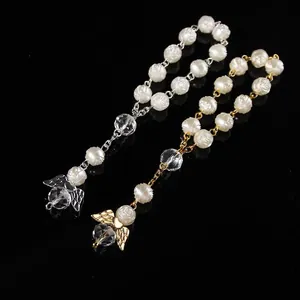 Detail of rose resin beads and crystal angel wing pendants in gold and silver finish