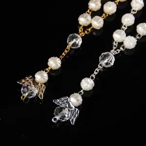 Macro detail of angel wing and rose charms on vintage style pearl beaded bracelets