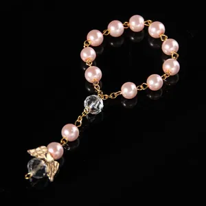 Detail of pink pearl beads with golden angel wing charm and faceted crystal pendant