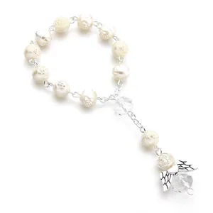 Close-up of heart-shaped rosary beads with rose motifs and angel wing charm detail