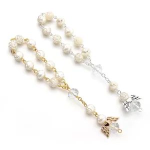 Detail of rose carved pearls and crystal beads with angel wing charms in gold and silver