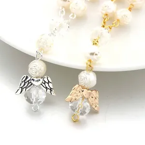 Detail of rosary bracelet with carved white rose, angel wing, and crystal beads