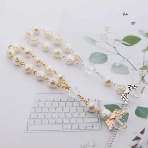 Detail of beaded rose pearl bracelets with butterfly charms on a lifestyle desk background