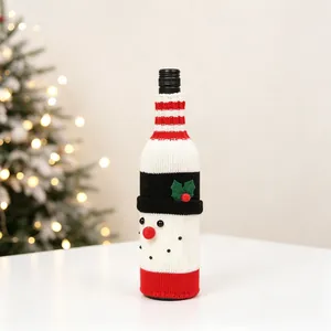 Close-up of a festive knitted snowman wine bottle cover with a belt on white tabletop