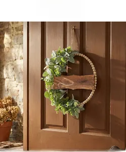 Détail de couronne en perles de bois avec eucalyptus et signe hello sur une porte