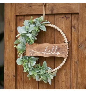 Détail du panneau en bois hello et des feuilles vertes sur la couronne de perles