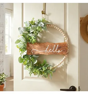 Détail de perles en bois et feuilles d'eucalyptus avec signe Hello sur une couronne