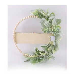 Vue détaillée de l'arrière d'une couronne en perles de bois avec feuilles vertes