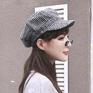 Close-up of stylish houndstooth newsboy cap featuring autumn winter woolen texture