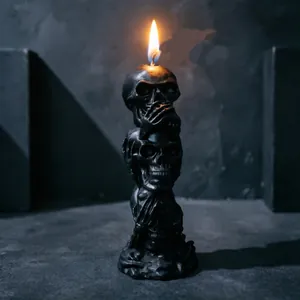 Detailed view of black triple skull candle with non-see hear speak design for Halloween