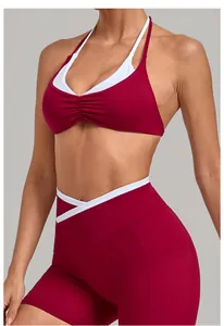 Detail von burgunderrotem Sport-BH mit weißen Neckholder-Trägern und V-förmiger Cross-Over-Leggings