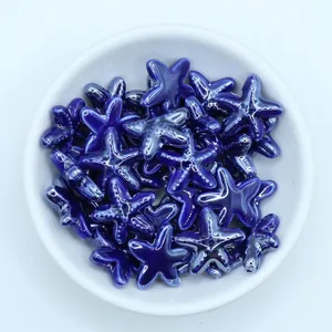 Macro detail of blue glazed starfish ceramic beads for DIY jewelry making in a white bowl
