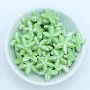 Macro shot of light green glazed starfish ceramic beads for handmade jewelry DIY