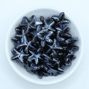 Macro shot of metallic starfish ceramic beads for DIY jewelry in a white bowl