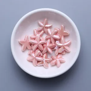 Close-up of pearl pink starfish ceramic beads for DIY jewelry making in a white bowl