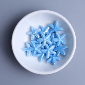 Close-up of bright sky blue starfish ceramic beads for DIY jewelry making in a white bowl