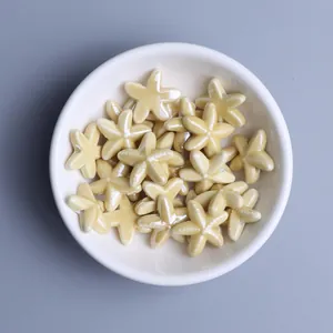 Macro view of light yellow starfish ceramic beads in a white bowl for DIY jewelry