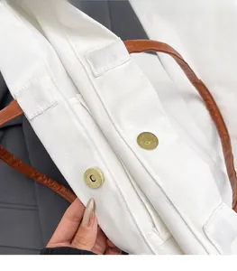 Detail of the high-quality gold magnetic snap button on white canvas tote bag