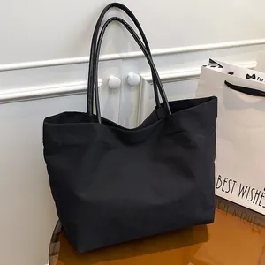 Minimalist black large capacity canvas tote bag with slim leather handles for women