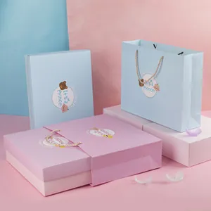 Detail of blue and pink baby gift box set with It's a Prince cartoon bear label