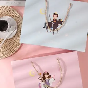 Detail of baby gift bags with cute cartoon prince and princess prints and rope handles