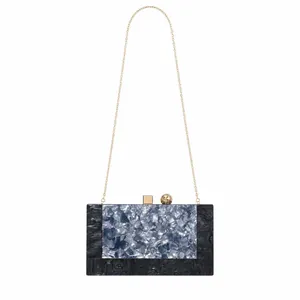 Macro view of blue and grey marble texture acrylic evening clutch with gold metal hardware