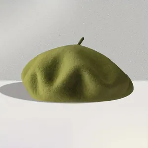 Close-up of a high-weight wool beret in dark green with a classic top stalk detail