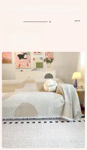 Détail de la housse de canapé en gaufre beige avec motifs géométriques et franges