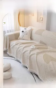 Détail de la texture gaufre d'une housse de canapé géométrique beige à franges