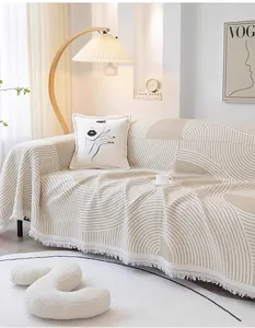 Vue détaillée de la housse de canapé gaufrée avec motifs géométriques et pompons boho