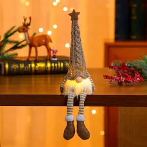 Detail of a glowing Christmas gnome with warm LED light and striped knitted legs