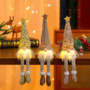 Three Christmas gnomes with glowing LED beards and striped legs sitting on a wooden edge