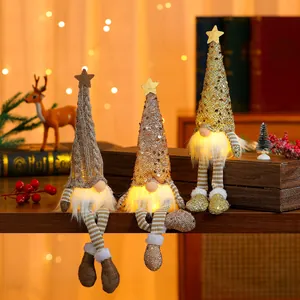 Close-up of three glowing Christmas gnomes with warm LED lights and glittery star hats