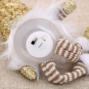 Detail of plush Christmas doll showing the battery compartment and on-off power switch