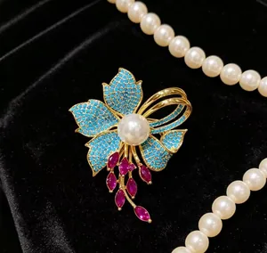 Dettaglio della spilla a iris vintage con perla e petali turchesi su velluto nero
