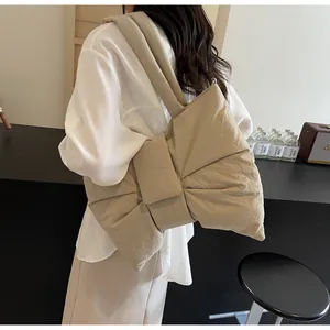 Detail of beige bow tote bag showing wrinkled fabric texture and large silhouette