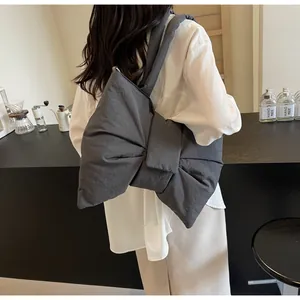 Close-up of a large bow-shaped oversized tote bag in charcoal grey with pleated fabric texture