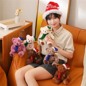 Group of colorful Christmas teddy bears with sequin hats and scarves on a cozy sofa