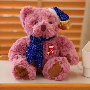 Detailed close-up of pink plush teddy bear with sequined Christmas hat and Happy Bear embroidery