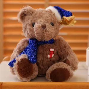 Detail of plush Christmas bear with blue sequin hat, scarf and happy bear foot embroidery