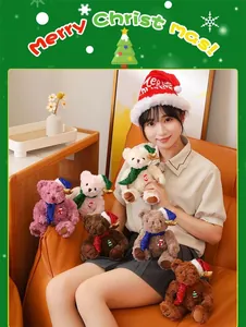 Close-up of Christmas teddy bears with sequin scarves and festive hats on a leather sofa