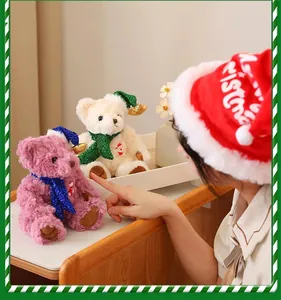 Detail of Christmas teddy bear with plush scarf, golden bell hat and Happy Bear embroidery