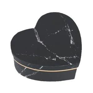 Black heart-shaped gift box with white marble pattern and elegant gold trim accents